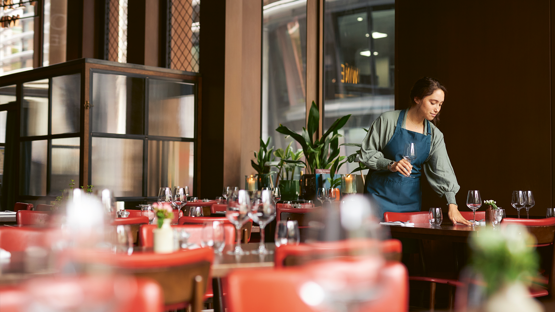 Servicekraft deckt einen Tisch im Restaurant