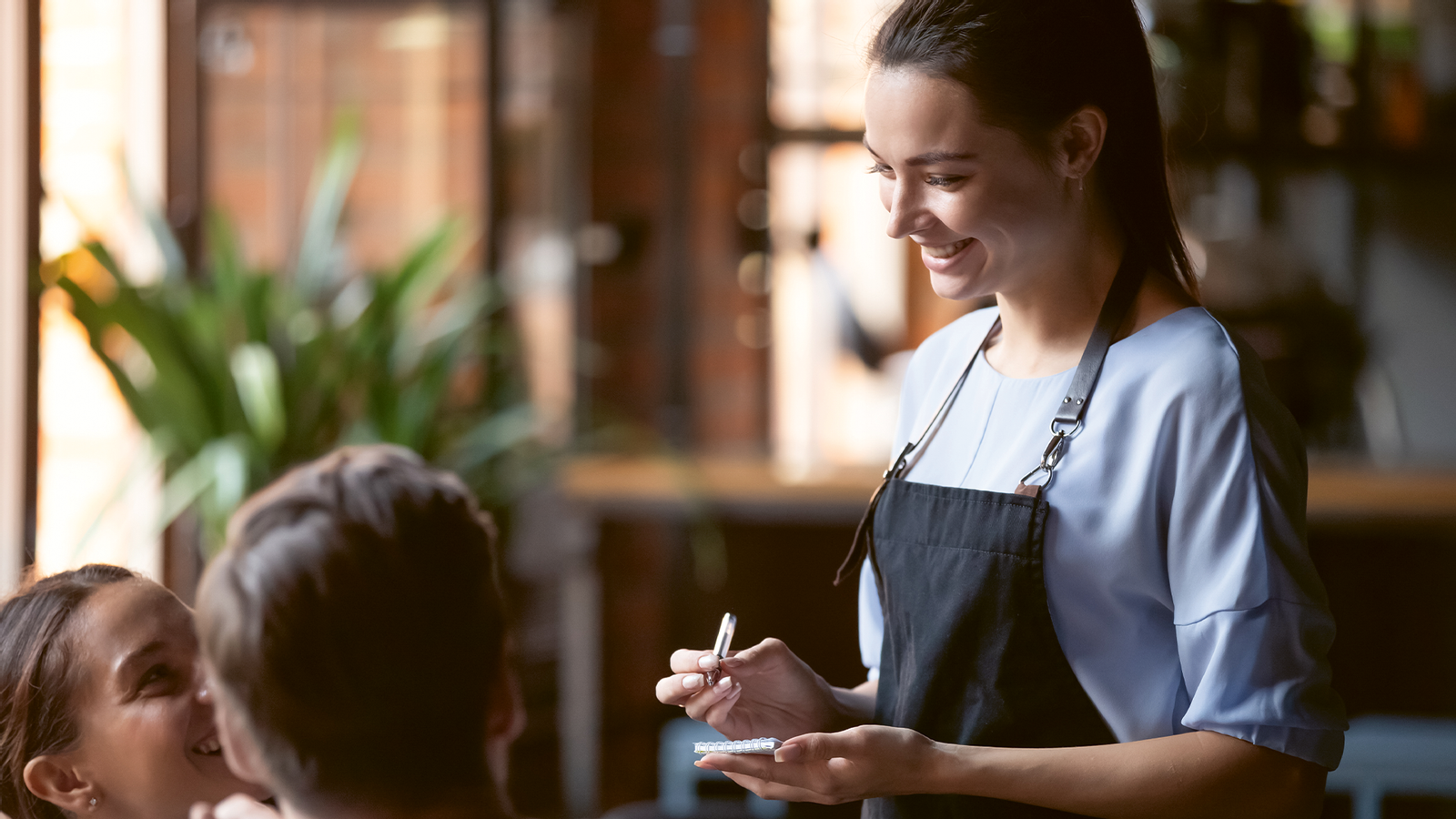 Servicekraft nimmt Bestellung im Restaurant auf