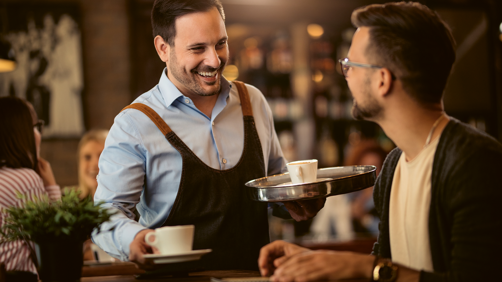 A waitress serves a coffee to a guest